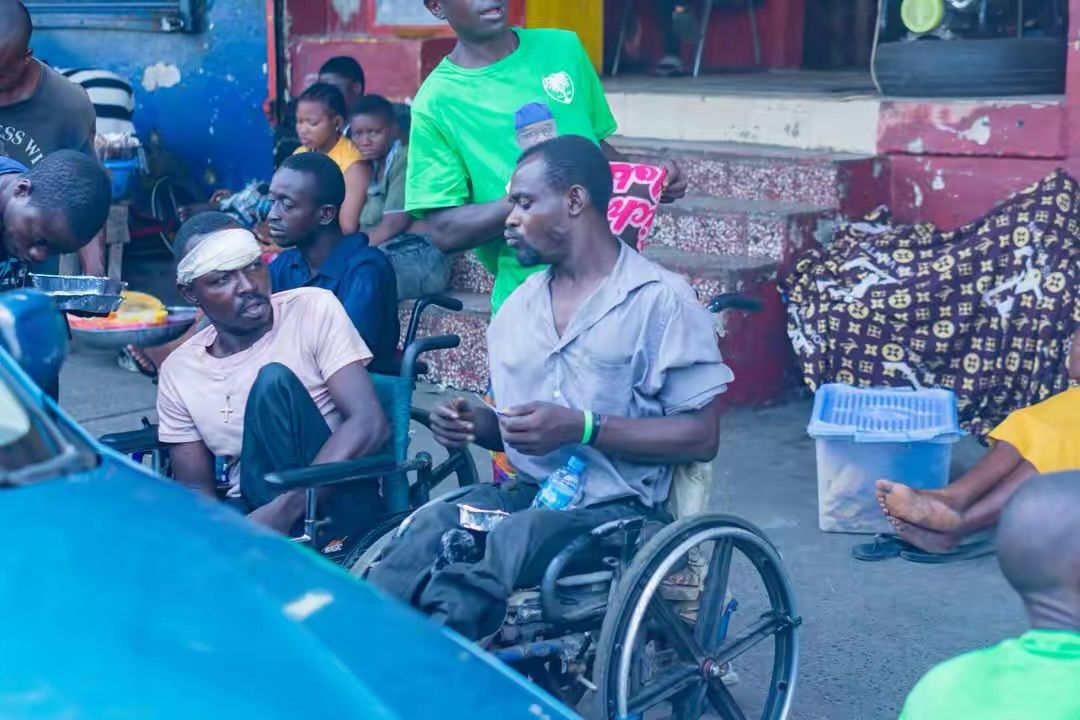 Two men in wheelchairs receive meals during a street outreach
