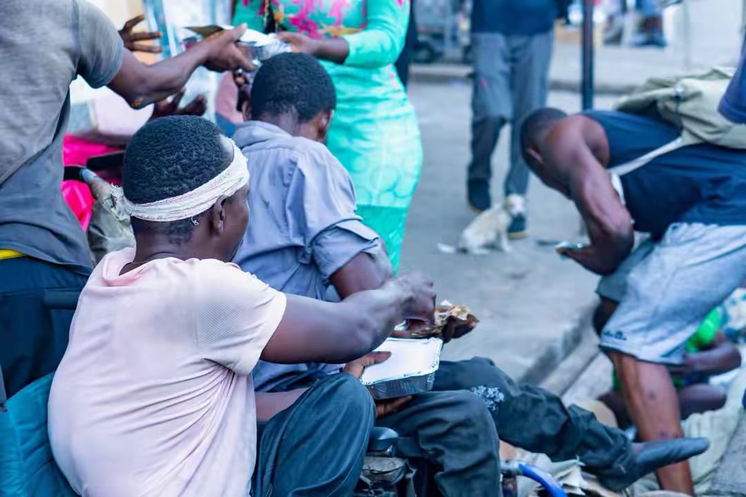 Volunteers greet people gathered for a street outreach meal