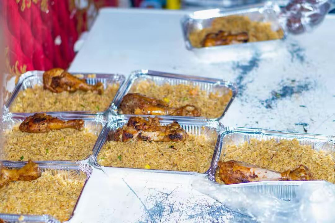Plates of rice and chicken prepared for a community meal