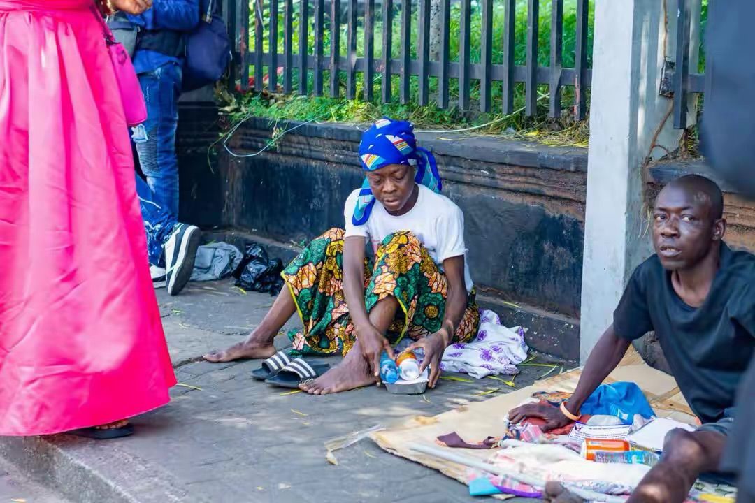 A volunteer hands a packed meal to a woman during a street outreach