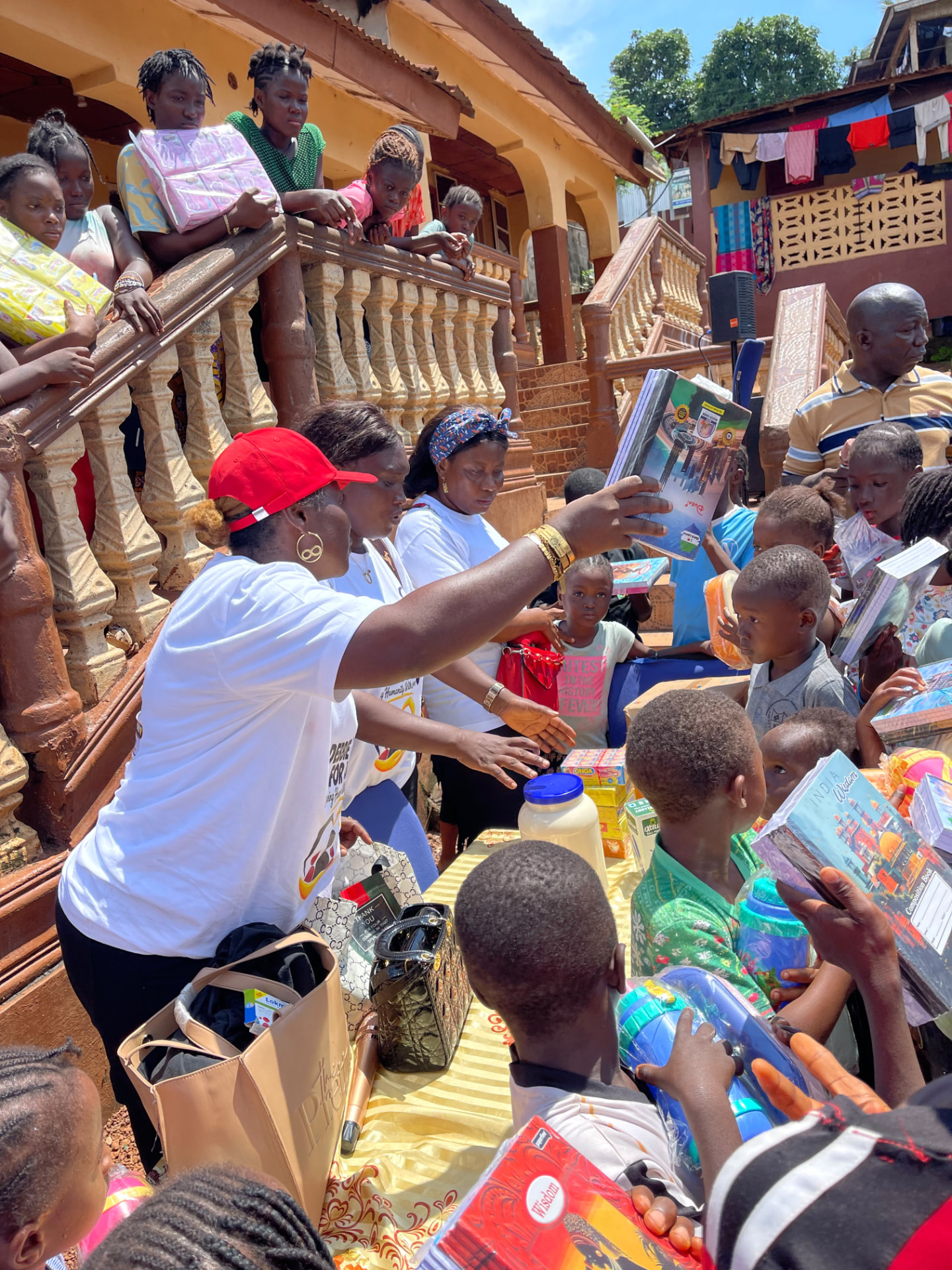 A volunteer hands out exercise books to children