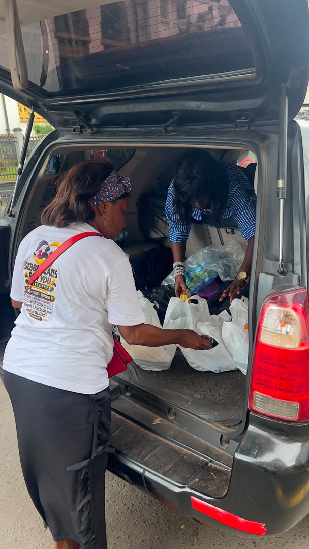 Volunteers load donated supplies into the back of a car